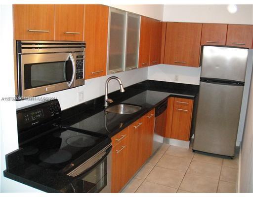a kitchen with granite countertop stainless steel appliances a stove a refrigerator a sink and dishwasher