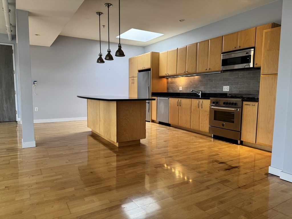 950 Dorchester Avenue, Unit 304 Boston, MA 02125 - Photo 1 of 42 a kitchen with stainless steel appliances a sink cabinets and wooden floor