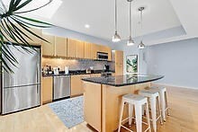 950 Dorchester Avenue, Unit 304 Boston, MA 02125 - Photo 30 of 42 a kitchen with stainless steel appliances granite countertop a sink refrigerator and cabinets
