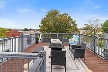 950 Dorchester Avenue, Unit 304 Boston, MA 02125 - Photo 40 of 42 a balcony with wooden floor table and chairs