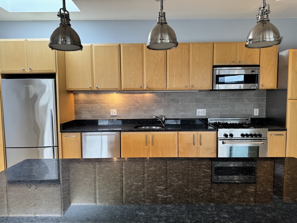 950 Dorchester Avenue, Unit 304 Boston, MA 02125 - Photo 9 of 42 a kitchen with stainless steel appliances granite countertop a stove a sink and a refrigerator