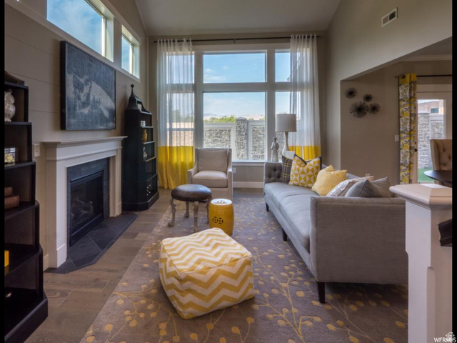 9294 South Rose Cottage Way, Unit 207 Sandy, UT 84094 - Photo 5 of 10 Living room with dark wood-style floors, a glass covered fireplace, plenty of natural light, and lofted ceiling