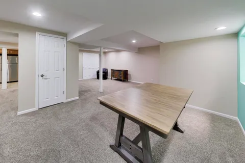 an empty room with kitchen view and wooden floor
