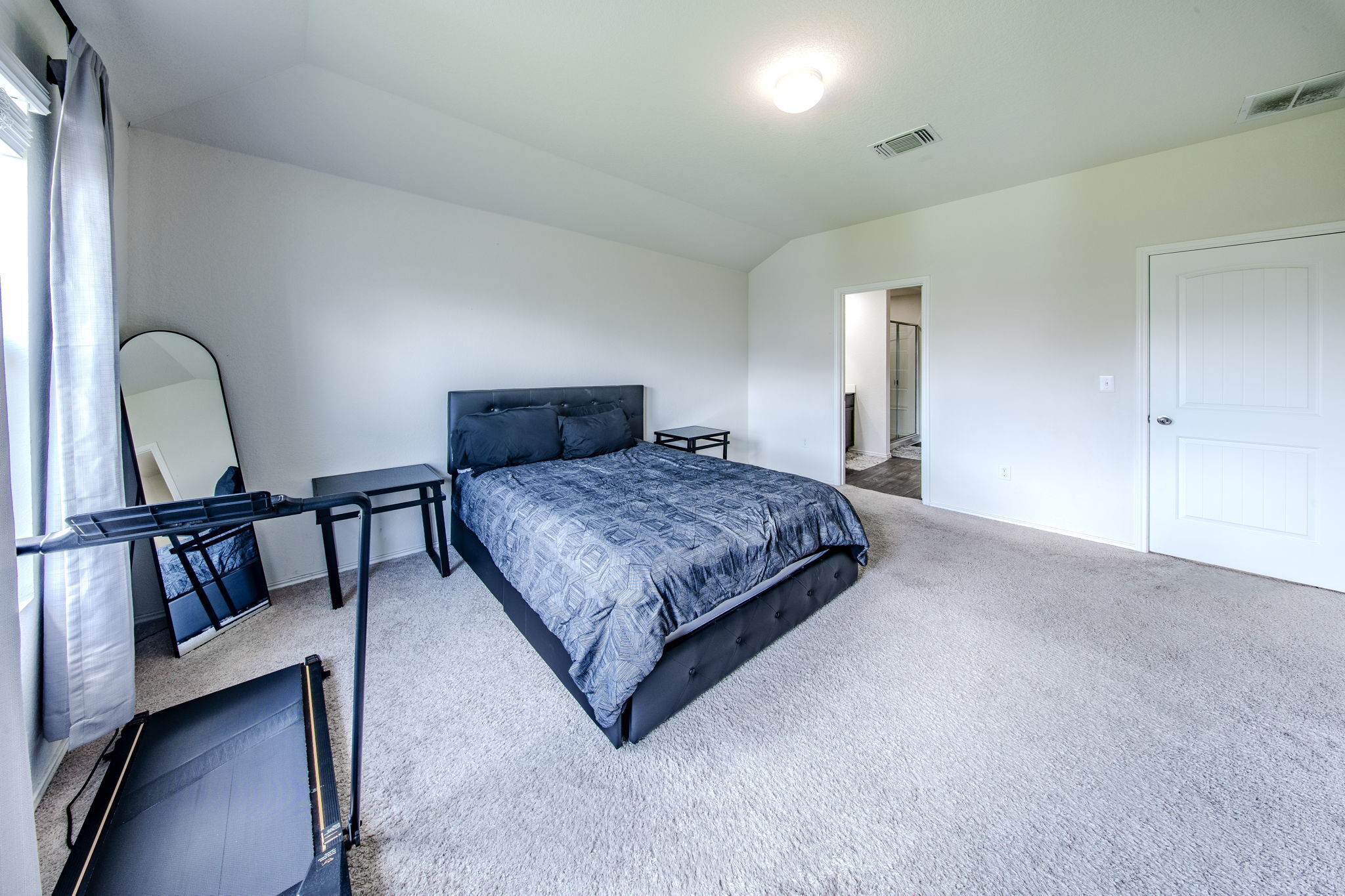 14903 Tuff Road Manor, TX 78653 - Photo 8 of 25 Naturally illuminated bedroom with soft carpeting and a clear view to the adjoining bathroom.