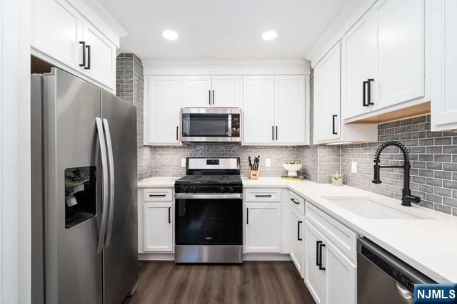 141 Park Avenue, Unit 8A East Rutherford, NJ 07073 - Photo 7 of 22 a kitchen with stainless steel appliances a refrigerator stove and white cabinets