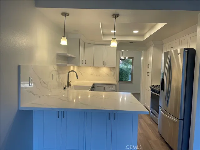 a large kitchen with stainless steel appliances a refrigerator and a sink