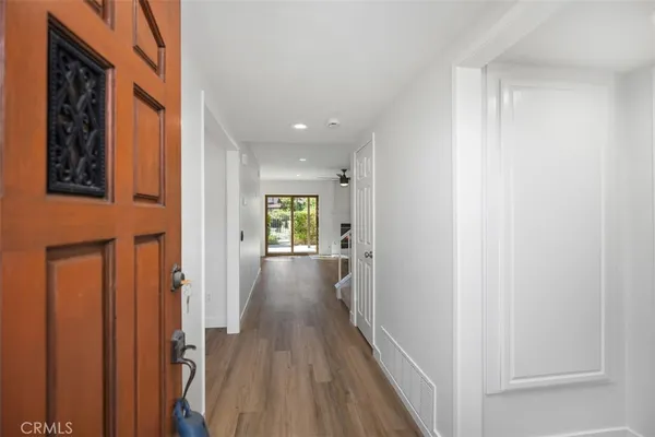 a view of a hallway with wooden floor and windows
