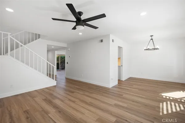 a view of a livingroom with wooden floor and a ceiling fan