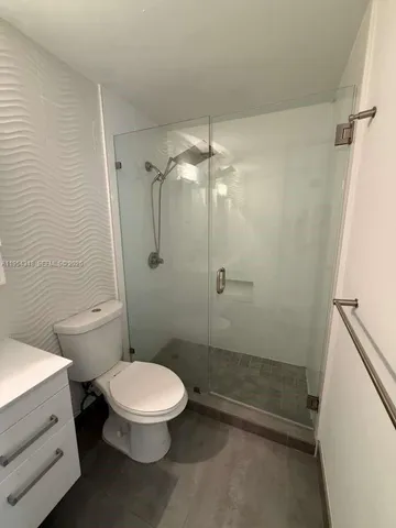 a bathroom with a toilet a sink and shower