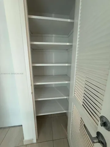 a view of walk in closet with empty racks