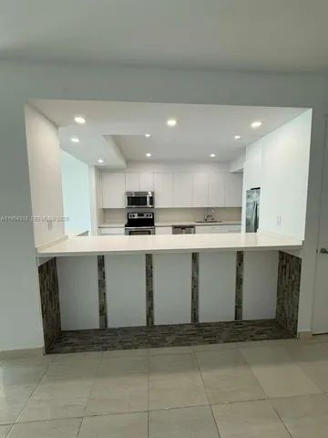a view of kitchen with stainless steel appliances cabinets