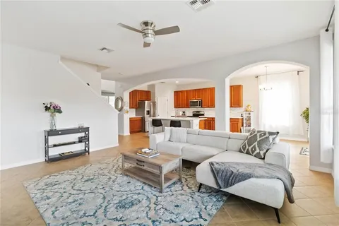 a living room with furniture and view of kitchen