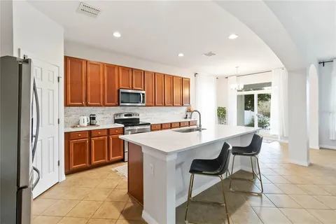 a kitchen with stainless steel appliances granite countertop a stove a sink a refrigerator a microwave and cabinets