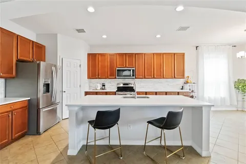 a kitchen with stainless steel appliances a refrigerator and a stove top oven