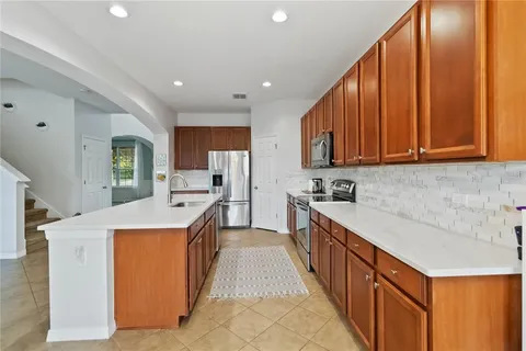 a large kitchen with stainless steel appliances granite countertop a large stove a sink dishwasher and a refrigerator with wooden floor