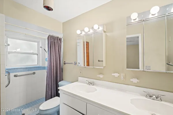 a bathroom with a sink a toilet and a mirror