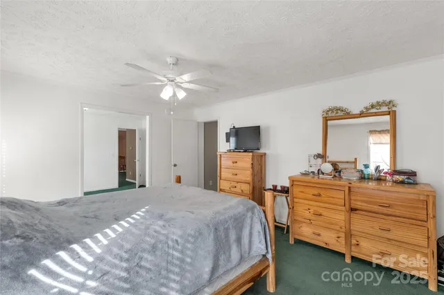 a view of an empty room with a window and a kitchen