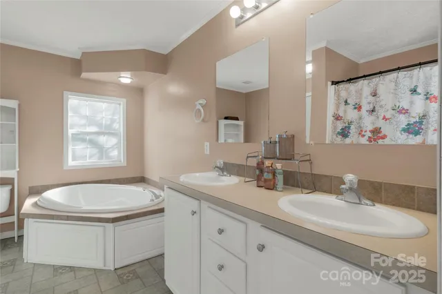 a living room with furniture a bookshelf and kitchen view