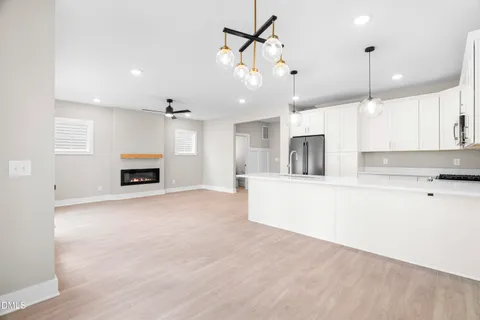 a kitchen with kitchen island a white cabinets and refrigerator