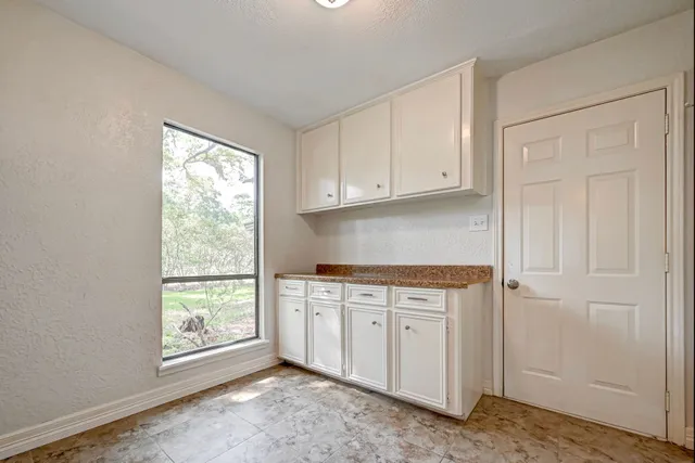 a kitchen with stainless steel appliances granite countertop white cabinets and window