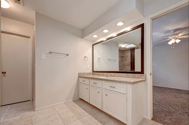 a bathroom with a granite countertop sink and a mirror