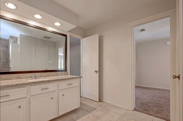 a bathroom with a granite countertop sink and a mirror