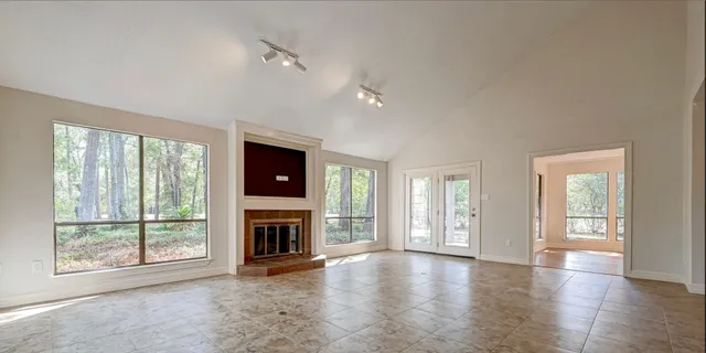 wooden floor fireplace and windows in an empty room