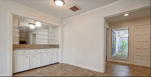 a room with a granite countertop sink and a mirror
