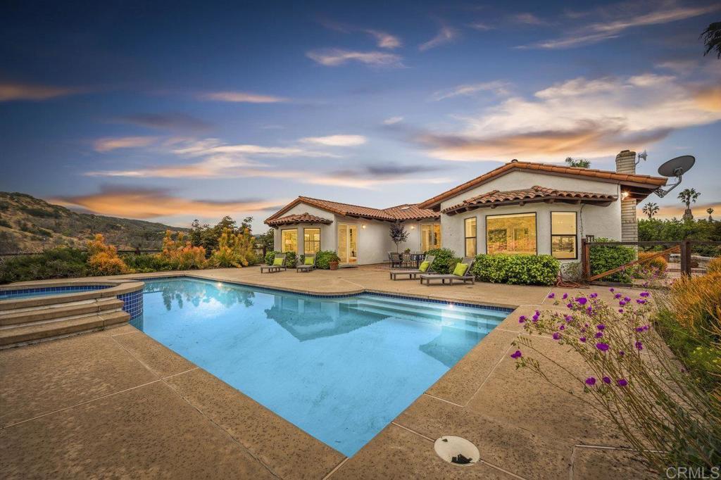 a view of a house with swimming pool and sitting area
