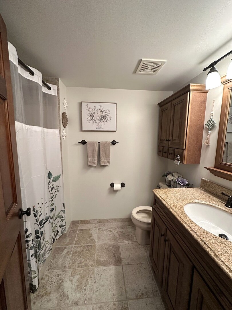 16806 82nd Avenue, Unit 3S Tinley Park, IL 60477 - Photo 11 of 14 a bathroom with a granite countertop sink toilet and shower