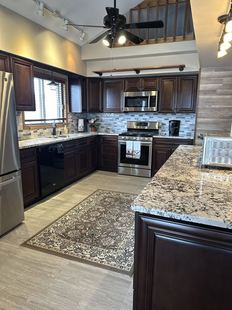 16806 82nd Avenue, Unit 3S Tinley Park, IL 60477 - Photo 2 of 14 a kitchen with stainless steel appliances kitchen island granite countertop wooden cabinets counter top and a stove