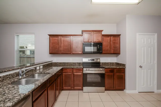 a kitchen with stainless steel appliances granite countertop a sink stove and cabinets