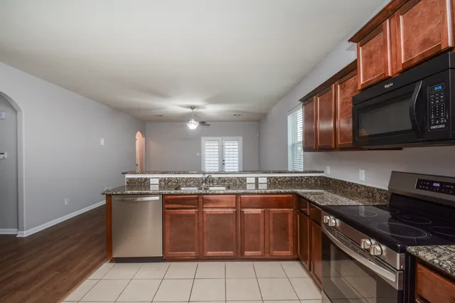 a kitchen with stainless steel appliances granite countertop a stove a sink and a microwave
