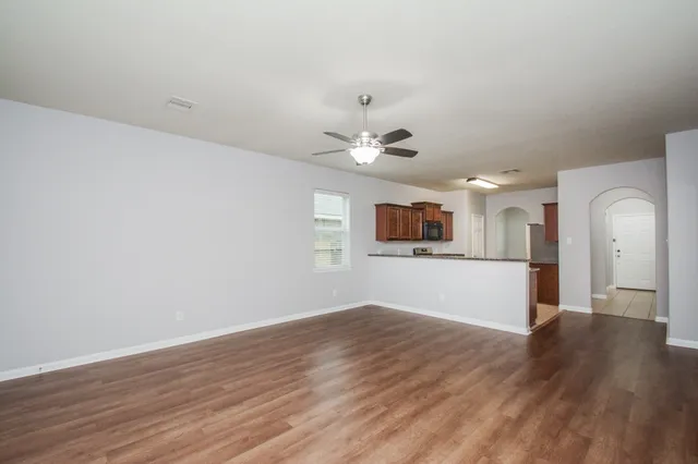 a view of a kitchen with wooden floor and a ceiling fan