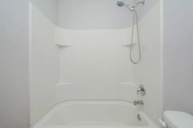 a bathroom with a bath tub with a shower