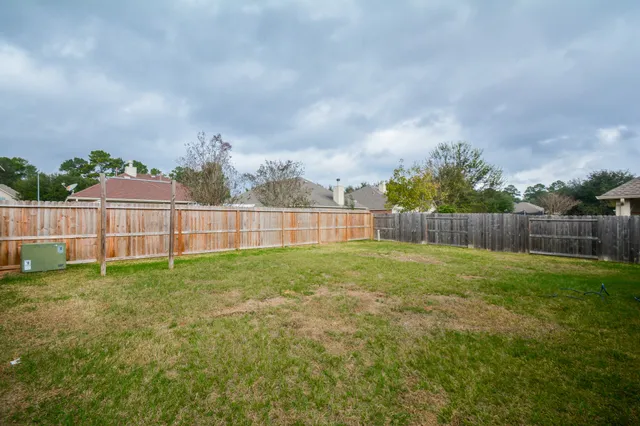 a view of a yard with a big yard and wooden fence
