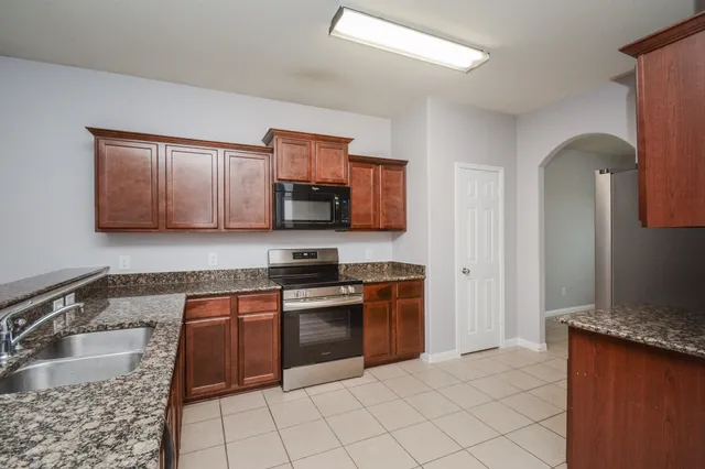 a kitchen with stainless steel appliances granite countertop a sink stove microwave and cabinets