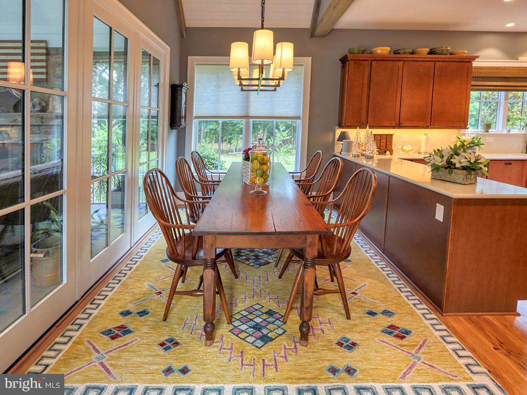35975 Goshawk Court Lewes, DE 19958 - Photo 26 of 94 a view of a dining room with furniture a chandelier and wooden floor