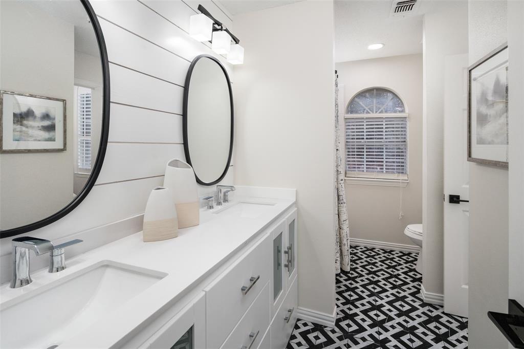 14604 Hemingway Court Addison, TX 75001 - Photo 18 of 27 a bathroom with a double vanity sink toilet and a mirror