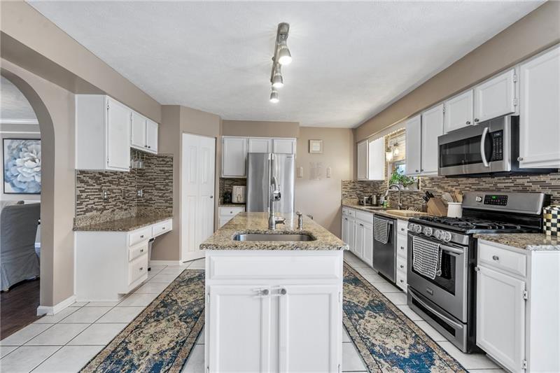 3013 Meyeridge Road Pittsburgh, PA 15209 - Photo 13 of 27 a kitchen with stainless steel appliances kitchen island granite countertop a sink stove and refrigerator