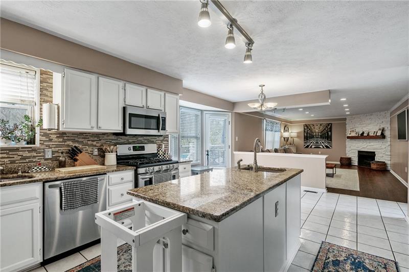 3013 Meyeridge Road Pittsburgh, PA 15209 - Photo 16 of 27 a kitchen with granite countertop a sink stove and cabinets