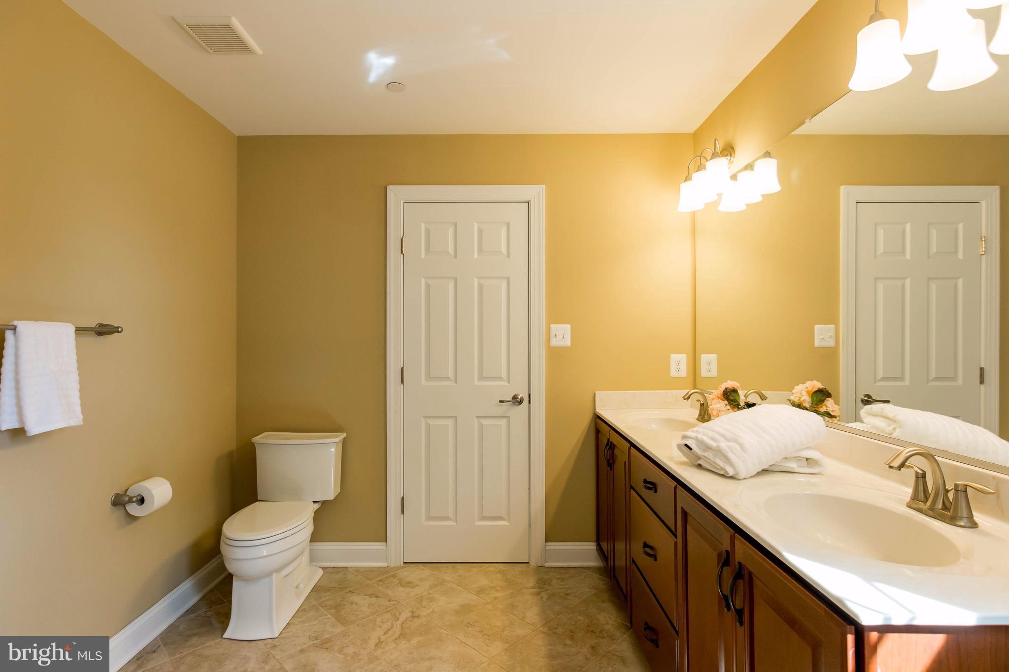3333 Whispering Highland Road Finksburg, MD 21048 - Photo 22 of 30 a spacious bathroom with a granite countertop sink a toilet and a mirror