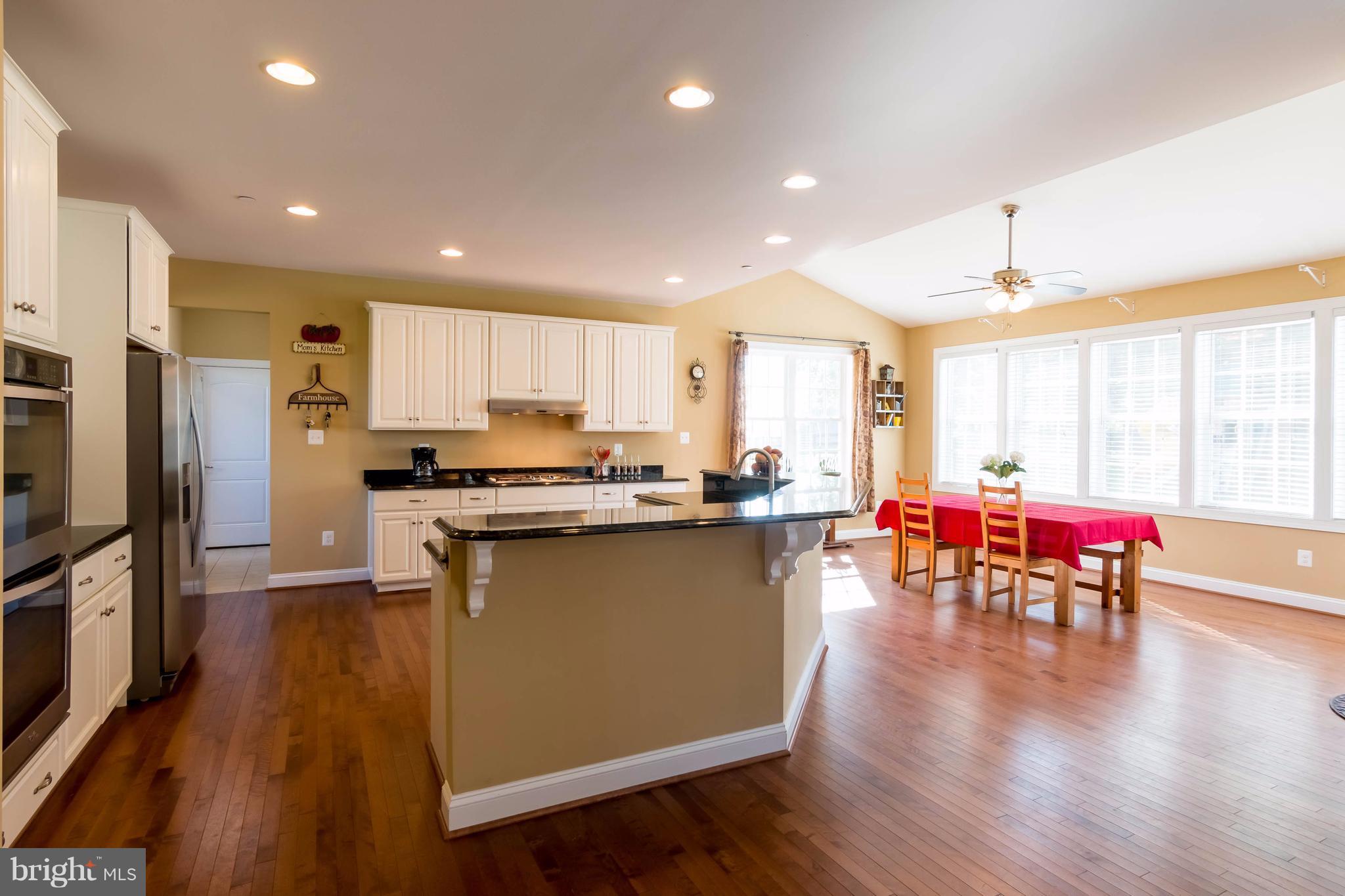3333 Whispering Highland Road Finksburg, MD 21048 - Photo 8 of 30 an open kitchen with wooden floor and stainless steel appliances