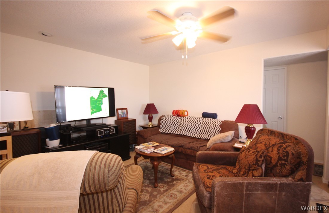 3408 Sunriver Road, Unit 109 Bullhead City, AZ 86429 - Photo 5 of 23 a living room with furniture a large window and a flat screen tv