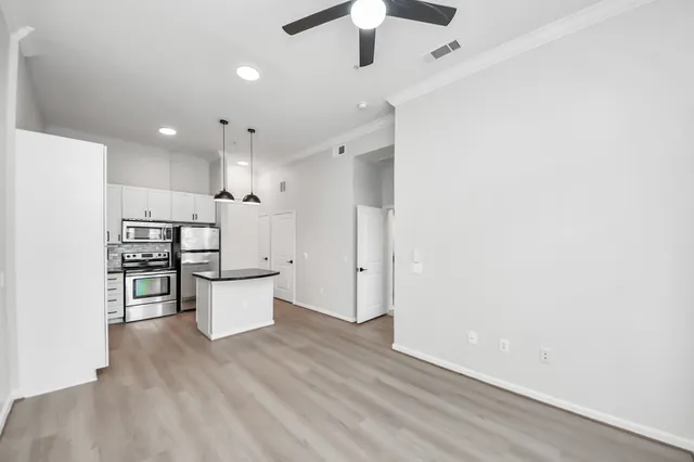 a kitchen with a refrigerator and white cabinets