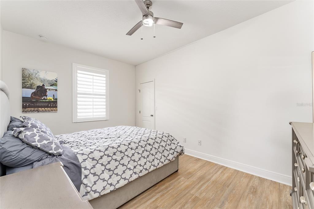4987 Southwest 63rd Loop Ocala, FL 34474 - Photo 41 of 56 a bedroom with a bed and wooden floor