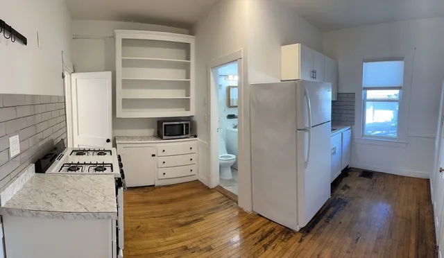 a kitchen with stainless steel appliances a refrigerator stove and cabinets