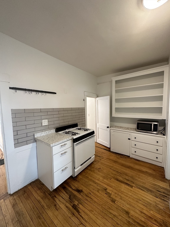 148 5th Street, Unit 2 Cambridge, MA 02141 - Photo 3 of 14 a kitchen with stainless steel appliances a stove and white cabinets