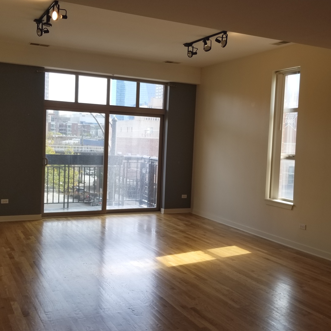 1910 South State Street, Unit 301 Chicago, IL 60616 - Photo 4 of 12 a view of an empty room with wooden floor and a window