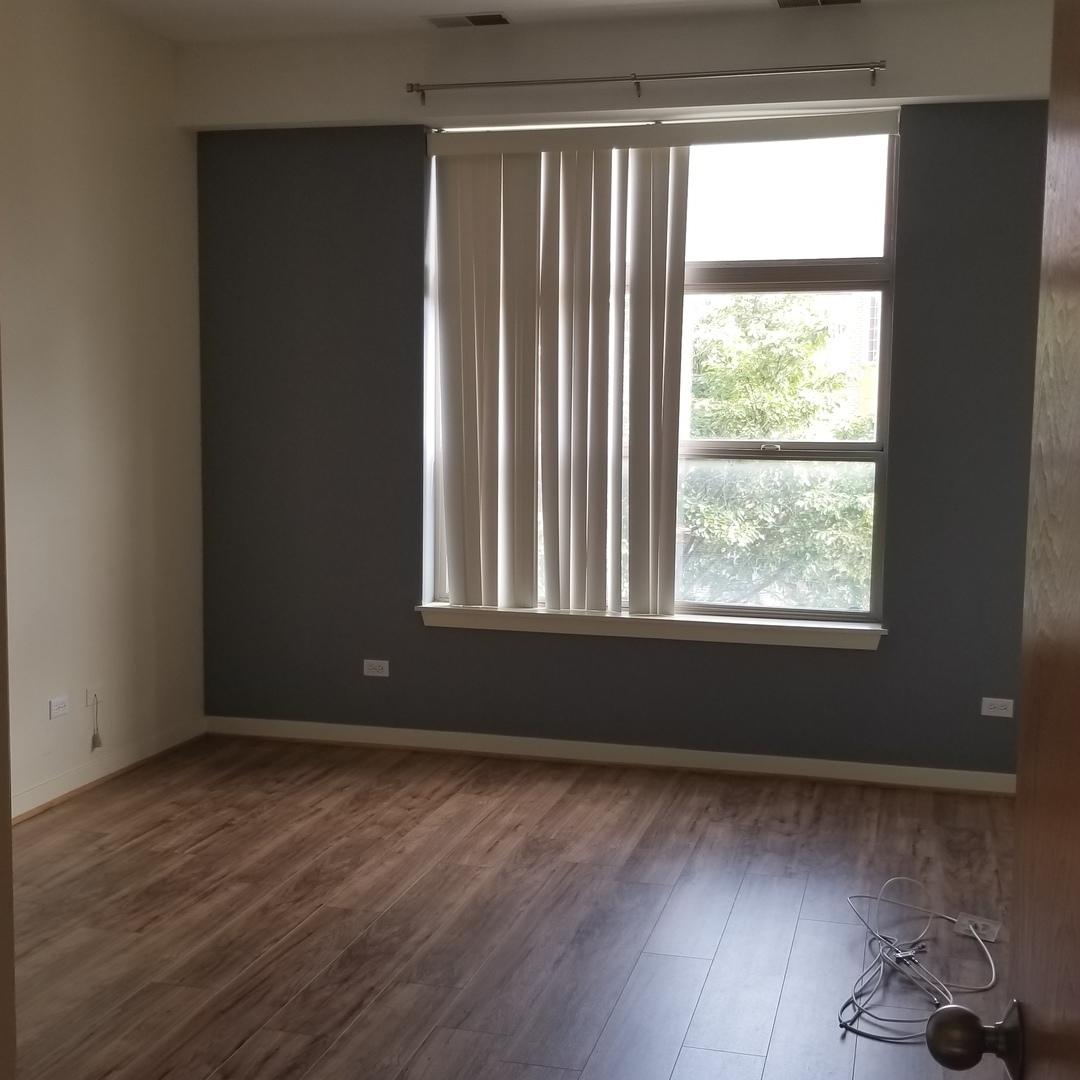 1910 South State Street, Unit 301 Chicago, IL 60616 - Photo 7 of 12 a view of an empty room with wooden floor and a window